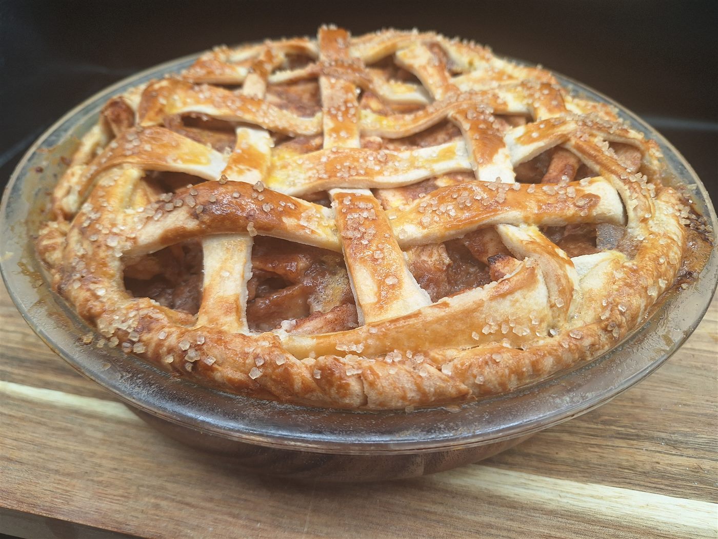 A golden lattice-top apple pie sprinkled with coarse sugar