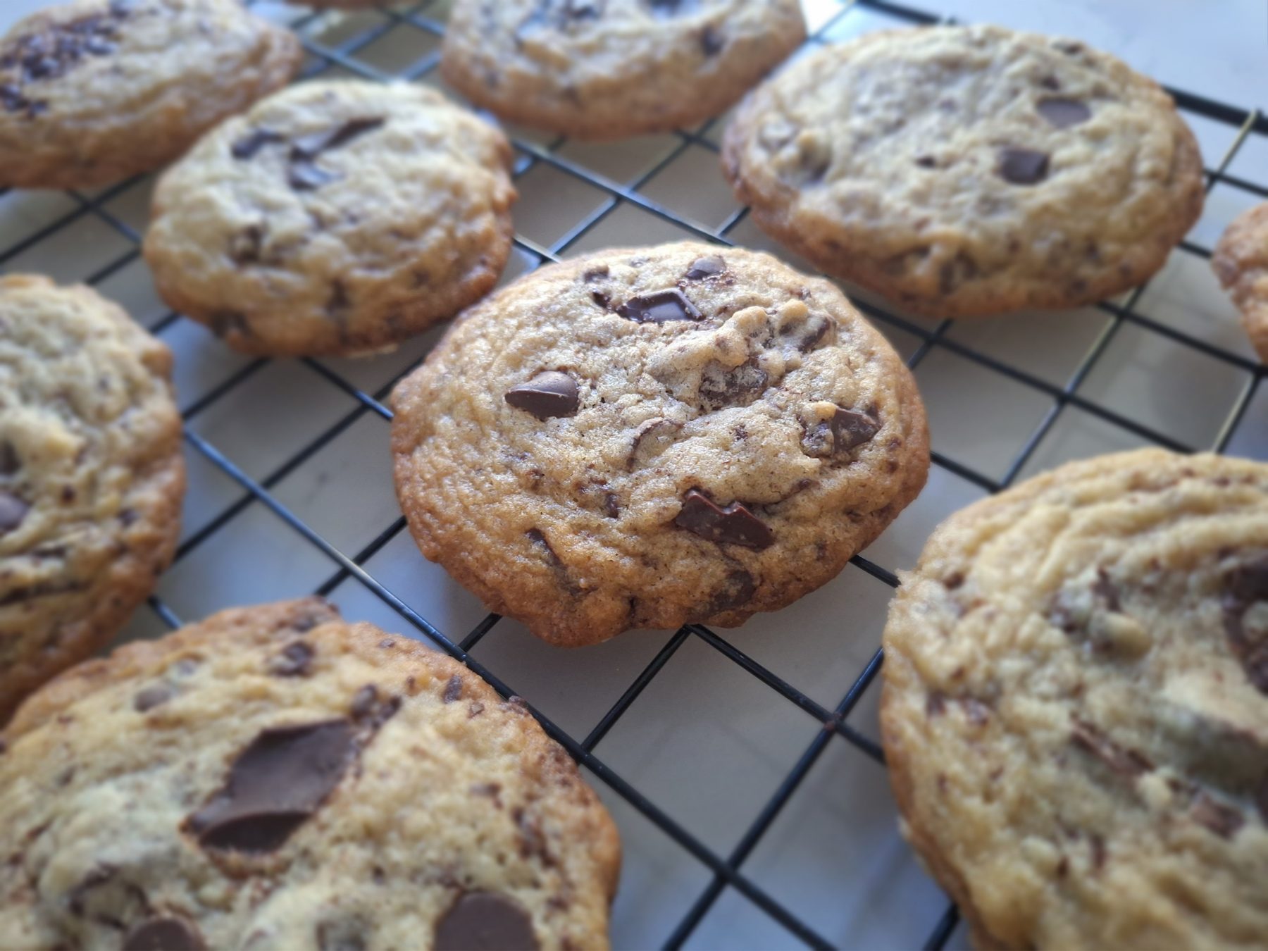 Maison Gigi Camelia Choco-Choco cookies cooling on a rack, studded with melting chocolate chunks